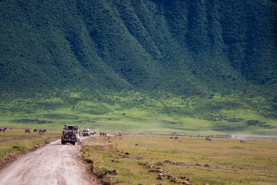 4x4 Safari trucks close to the steep walls of the Ngorongoro crater