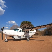 A light turboprob airplane (Cessna Grand Caravan) parking at an unpaved Selous Game Reserve airstrip. With our fly in Safari tours, you will arrive in the wilderness in less than one hour from Zanzibar