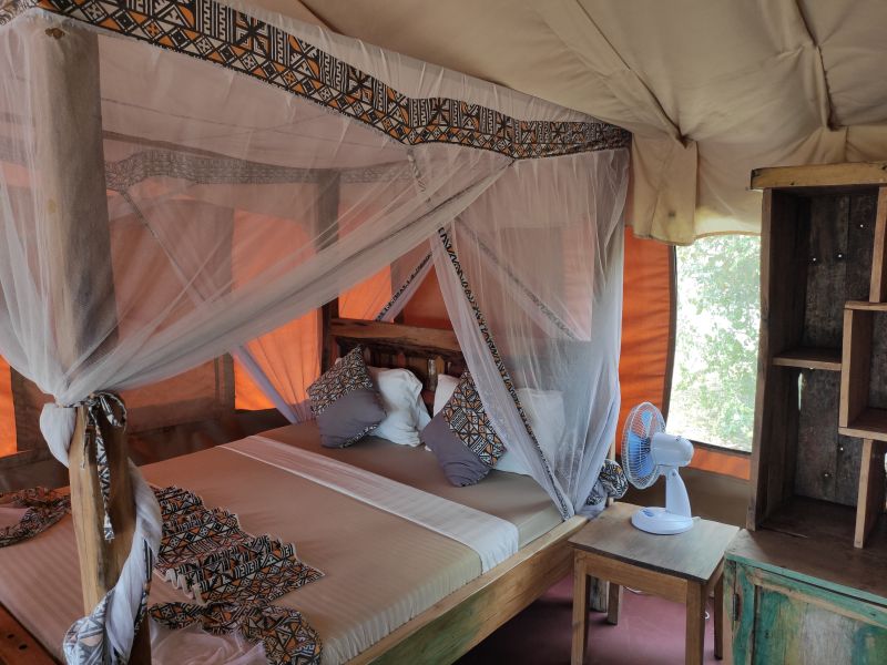A semi permanent tent with a king size bed in Africa Safari Lake Natron