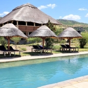 The swimming pool of Africa Safari Lake Natron with the Restaurant in the background